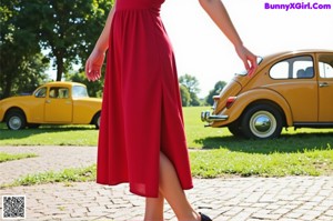 A woman in a red dress standing in a kitchen.