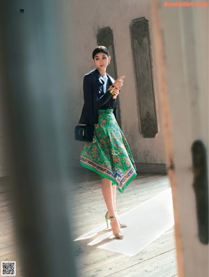 A woman holding a brown and tan bag in a magazine.