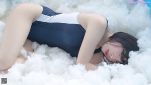 A woman laying on a couch wearing a black mask.