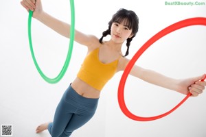 A woman holding a hula hoop in her hands.