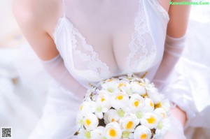 A woman in a white dress sitting on a chair.