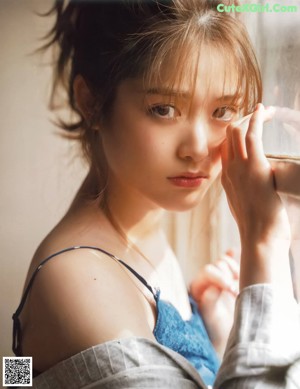 A woman holding a bowl of rice in front of a window.