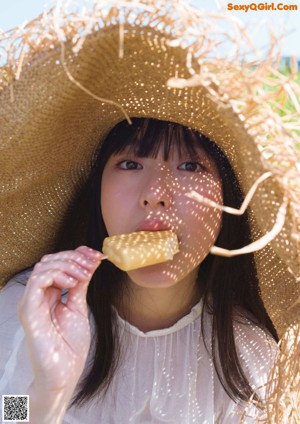 A woman in a bathing suit and a straw hat.