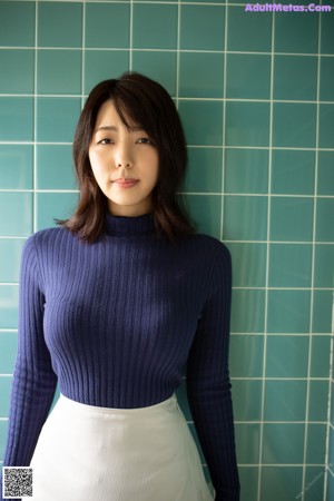 A woman in a blue sweater and black lingerie laying on the floor.