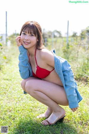 A woman in a red bikini and a denim jacket.