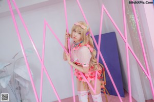 A woman in a pink and white outfit posing in front of a mirror.