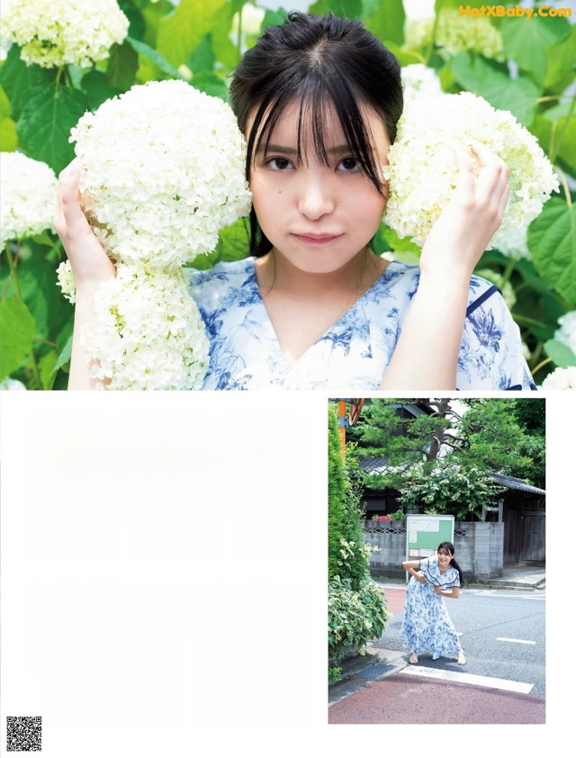 A woman holding a bunch of white flowers in front of her face.