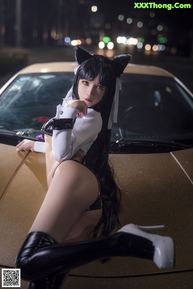 A woman in a cat costume sitting on top of a car.