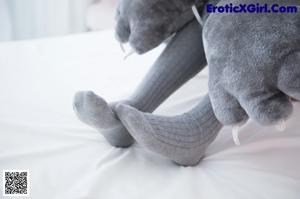 A woman in a cat costume sitting on a bed.