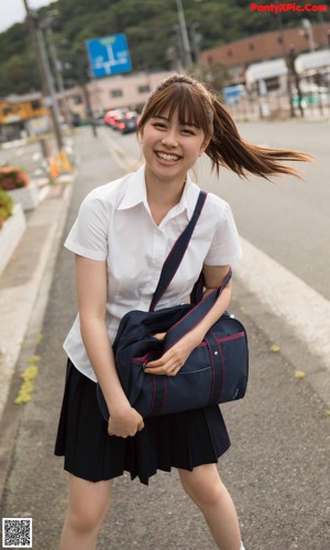 A woman in a school uniform standing on a boat.