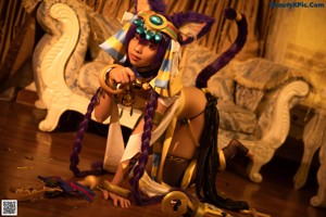 A woman in a costume is sitting on a bed.