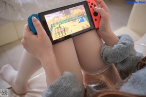 A woman sitting on a couch holding a cell phone.