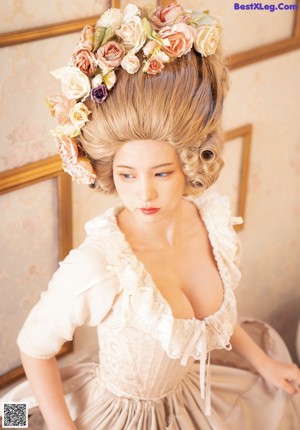 A woman in a blue dress holding a pink rose.