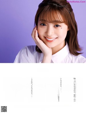 A woman in a white shirt dress sitting on a purple background.