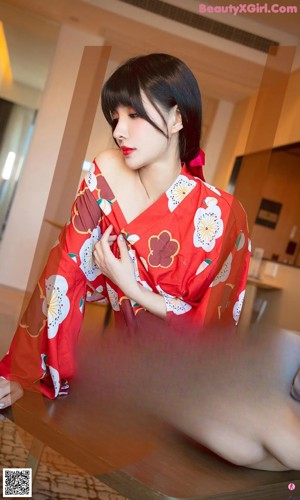 a woman in a red kimono standing on a bed