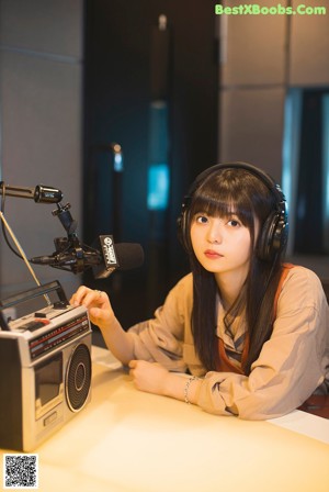 A woman sitting in a chair with headphones on.