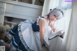 A woman in a blue and white dress is posing for a picture.