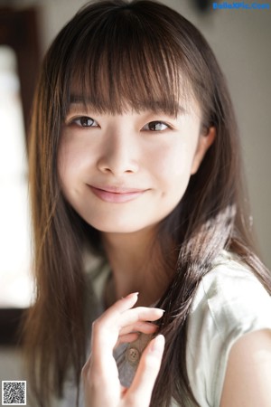 A woman standing in front of a window smiling.