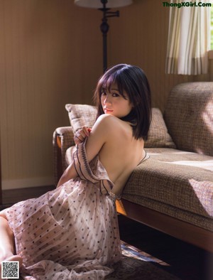 A woman laying on top of a bed in a white lingerie.