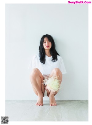 A woman laying on the floor with her legs crossed.